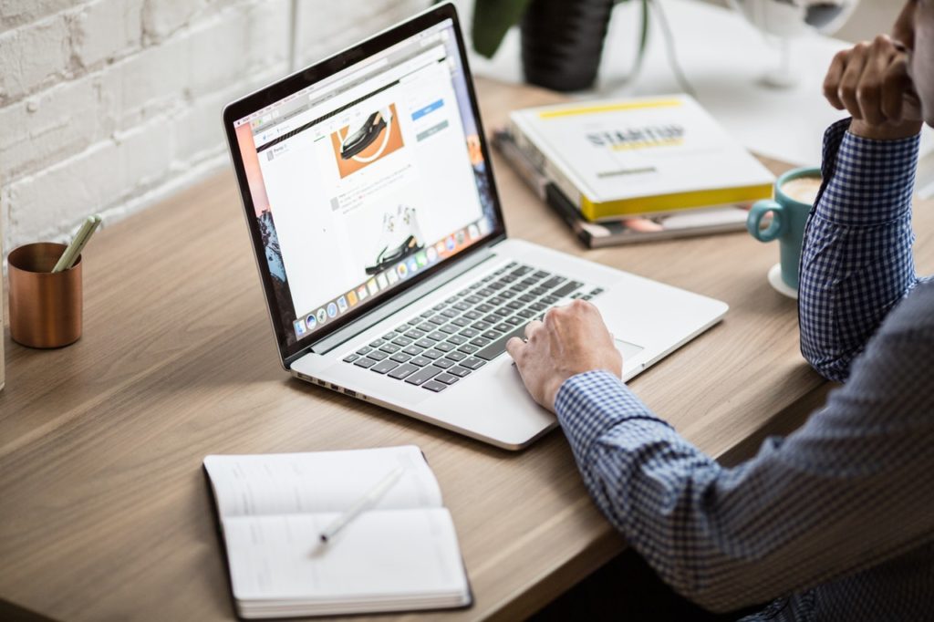 pessoa no notebook calculando quanto custa site em wordpress